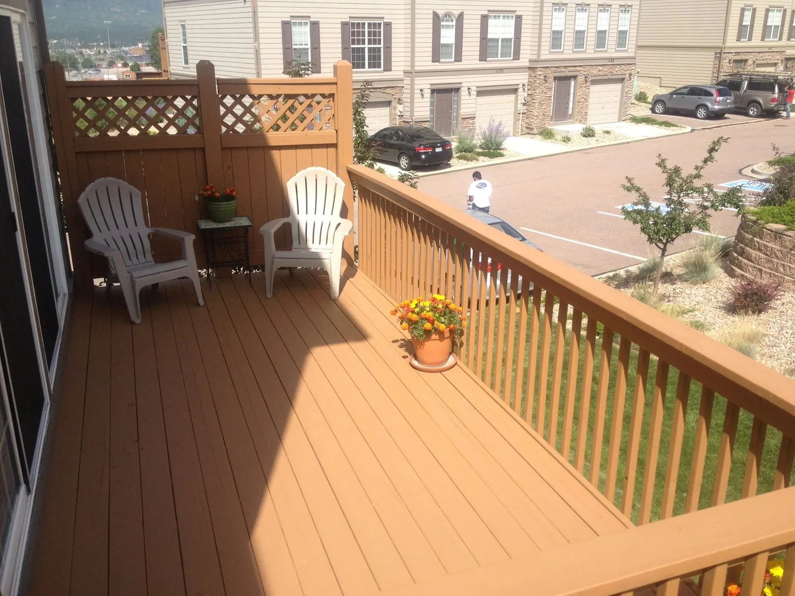 Freshly stained wood deck and railing on a townhome