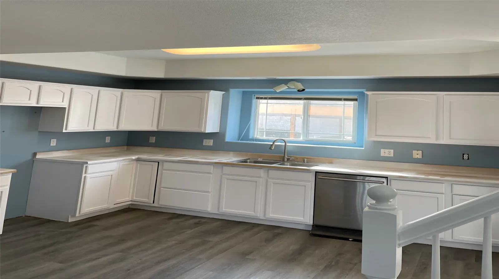 Kitchen with white cabinets and soft blue walls