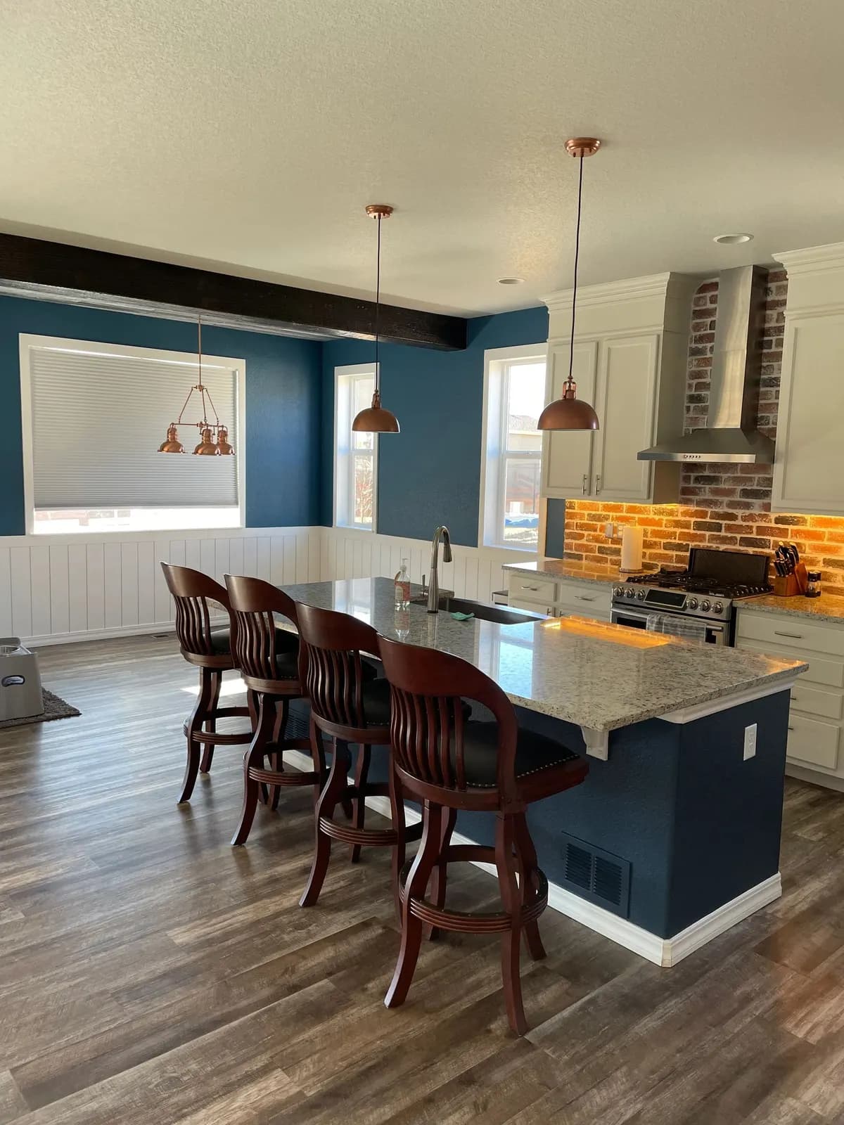 Open kitchen with a blue island, blue accent walls and white upper walls